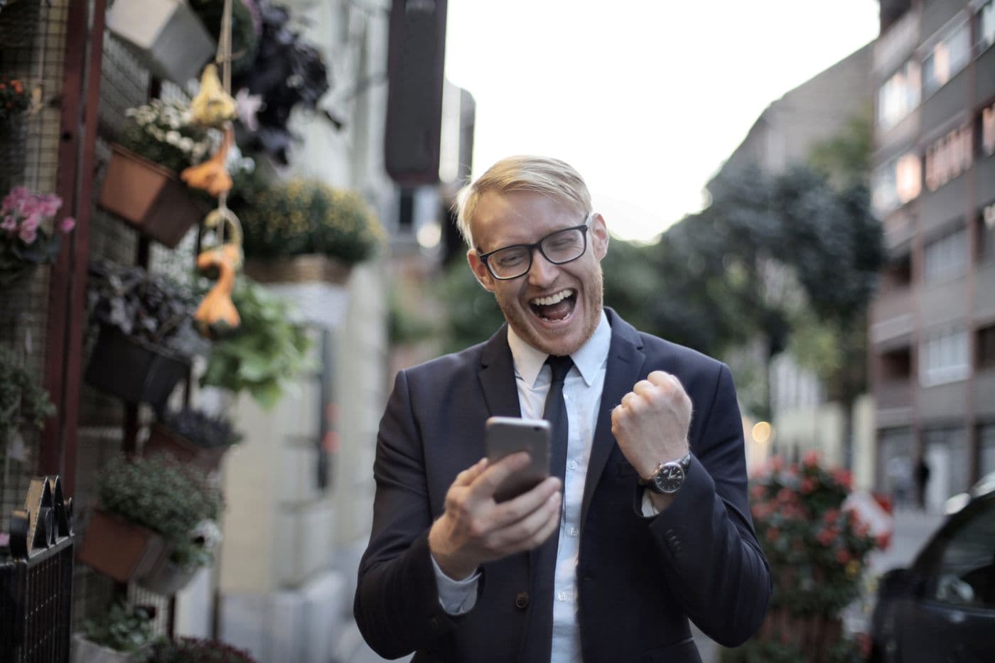 A business owner reacting with excitement to a new lead notification on their phone