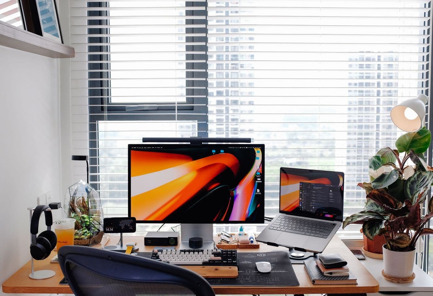 A tidy, organized dual-monitor workspace by a bright window