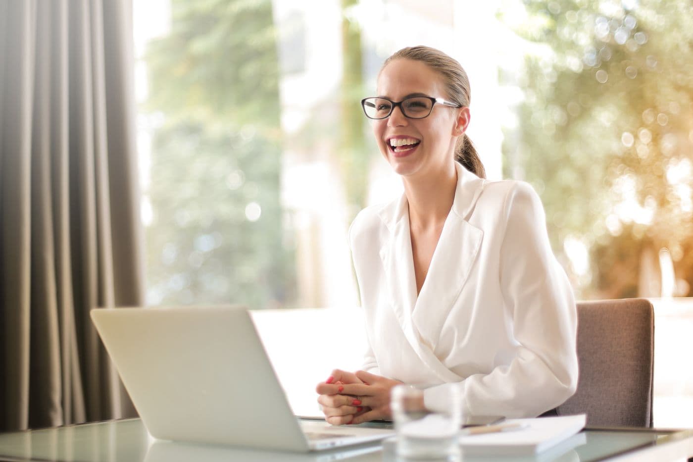 A calm, in-control small business owner working at a laptop in a modern workspace