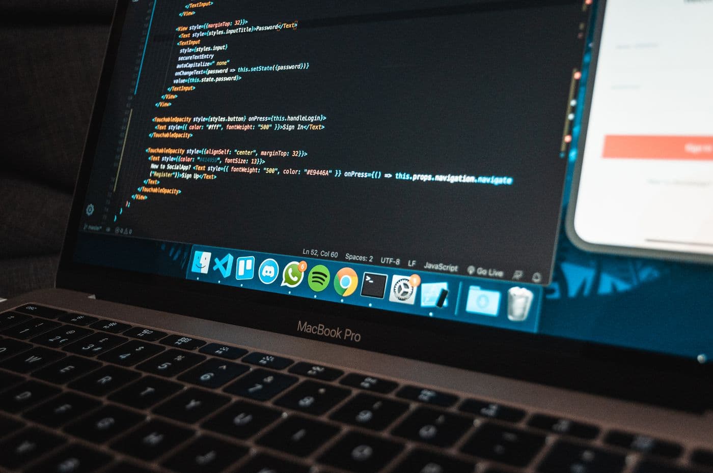 A developer editing website code in a code editor on a laptop
